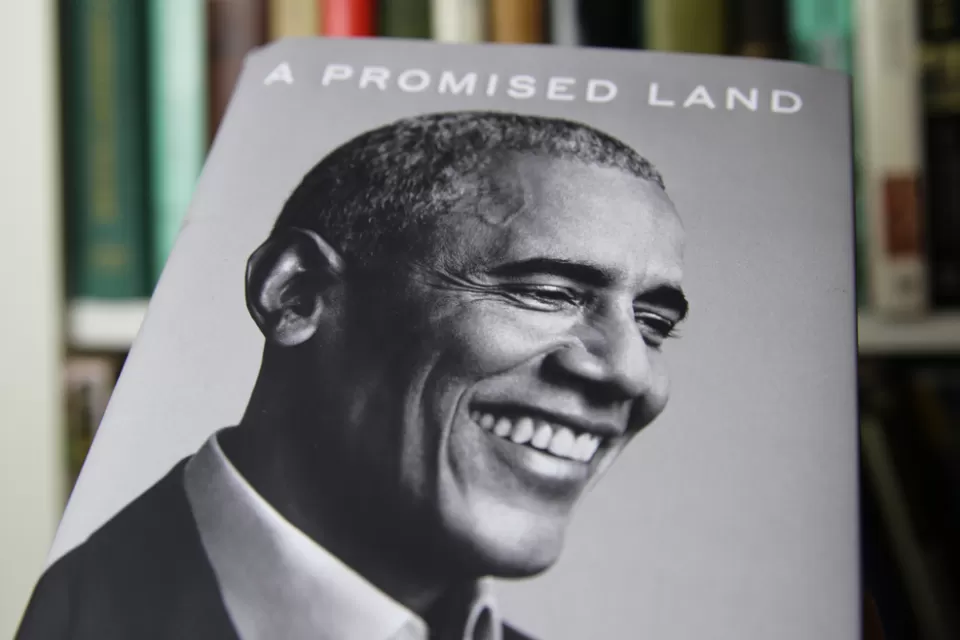 An image of the book "A Promised Land," by Barack Obama shows a black and white photo of the former president smiling.